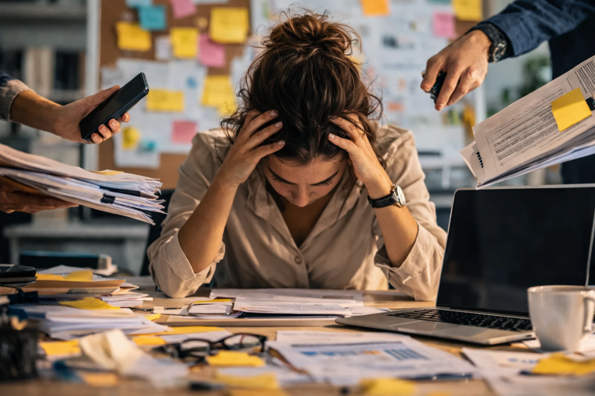 Stress lavoro-correlato in ufficio: lavoratrice sotto pressione con molte richieste e scadenze lavorative.